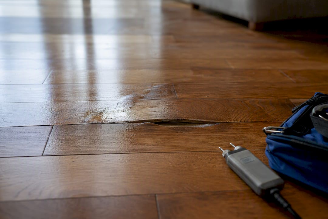 Cupped hardwood beside damp slab flooring