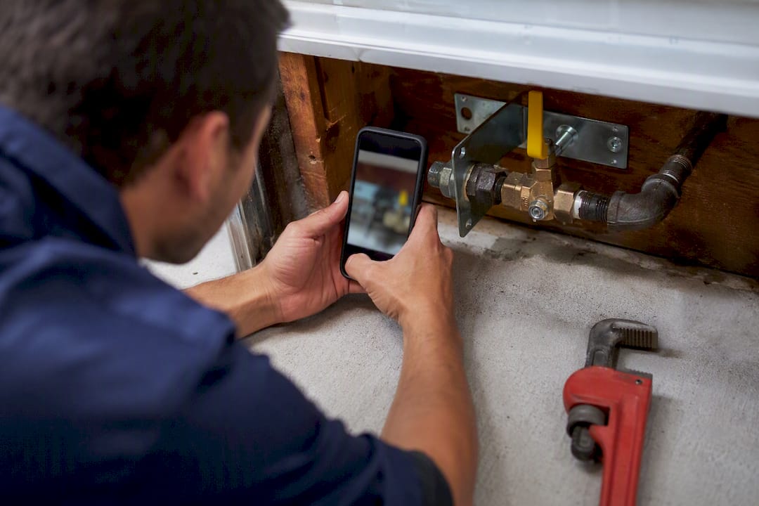 Technician photographing gas valve bracket